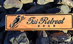 Carved tui into macrocarpa board with script font 